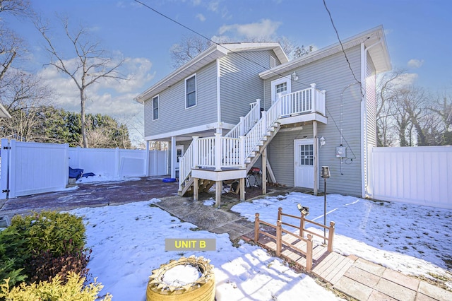 snow covered rear of property featuring a deck