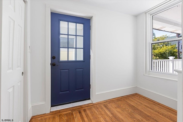 doorway featuring wood finished floors and baseboards