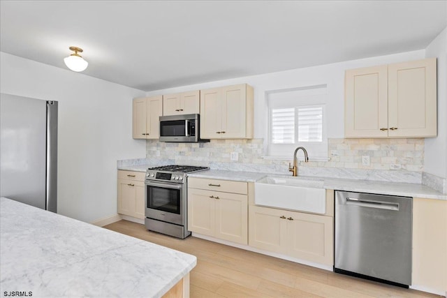 kitchen featuring light countertops, appliances with stainless steel finishes, backsplash, and a sink