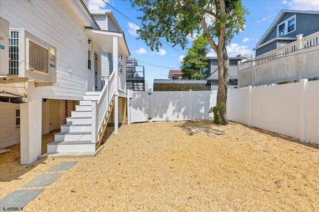 view of yard with stairs and a fenced backyard