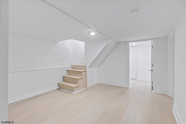 bonus room with stairway, baseboards, and wood finished floors