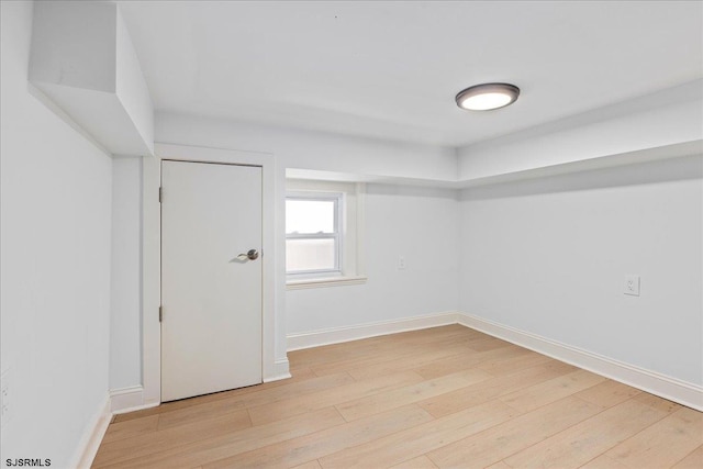 spare room featuring light wood-style flooring and baseboards