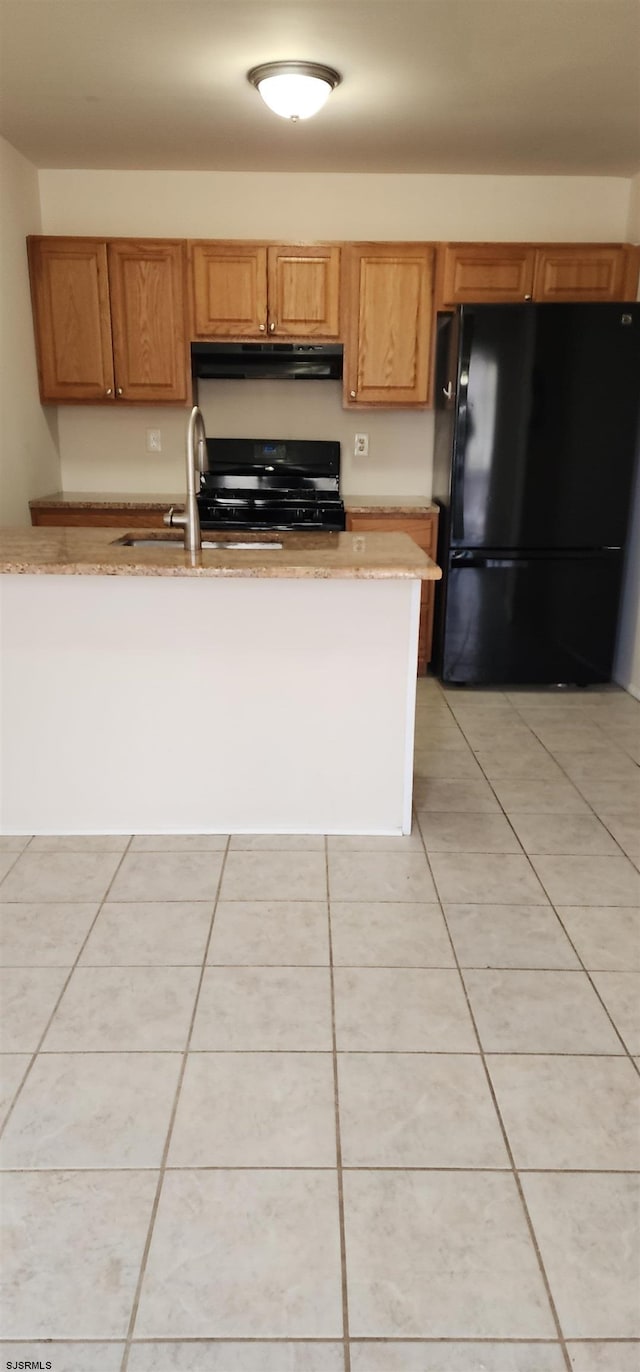 kitchen with light tile patterned flooring, sink, and black appliances