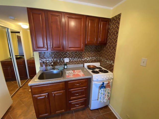 kitchen with backsplash, dark tile patterned floors, white electric range, and sink