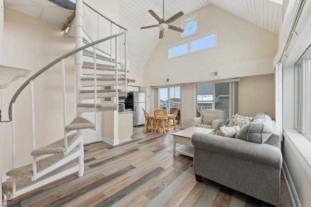 living room featuring ceiling fan, light hardwood / wood-style flooring, and high vaulted ceiling