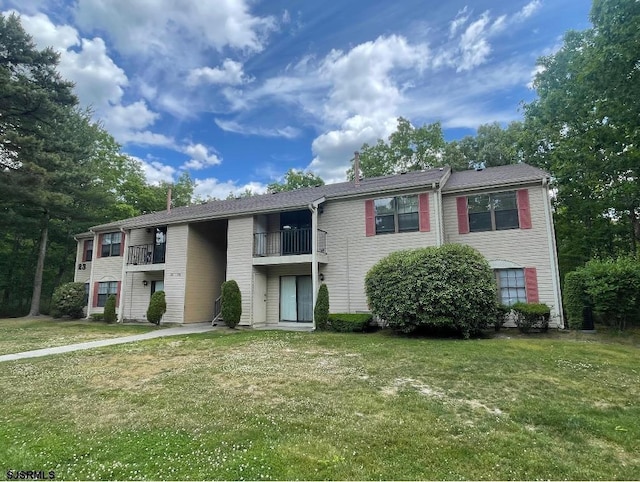 view of front of home featuring a balcony and a front lawn