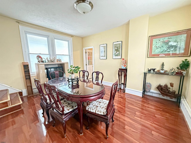 dining room featuring wood-type flooring and a textured ceiling