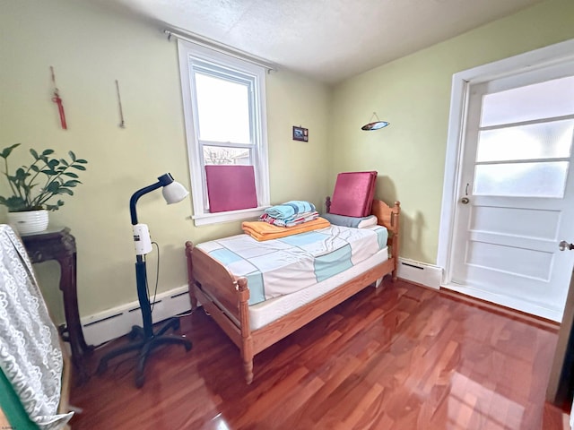 bedroom with baseboard heating and dark wood-type flooring