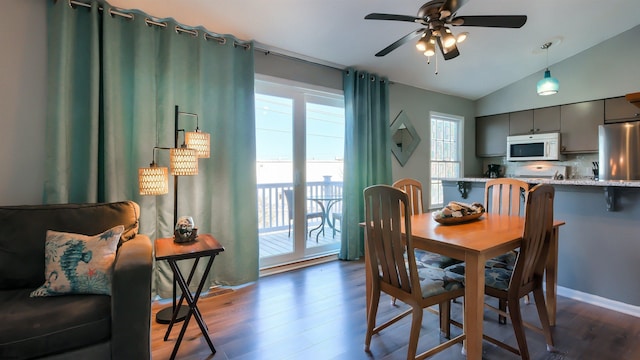 dining room with ceiling fan, dark hardwood / wood-style flooring, and lofted ceiling