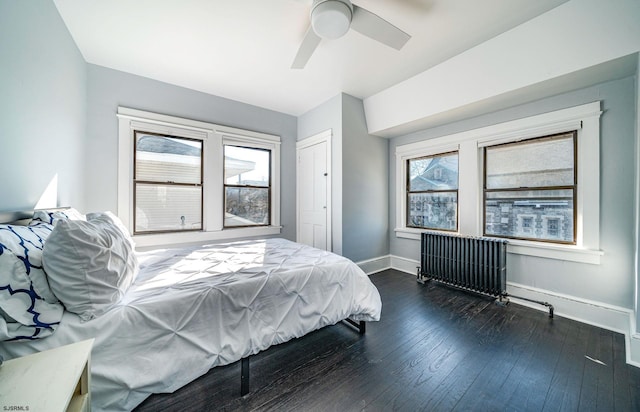 bedroom featuring dark wood-type flooring, ceiling fan, and radiator