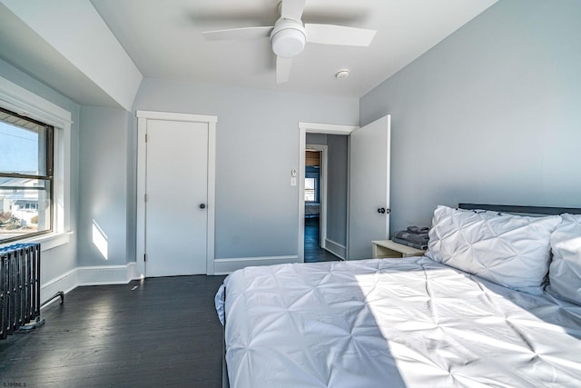 bedroom featuring dark hardwood / wood-style flooring, radiator, and ceiling fan