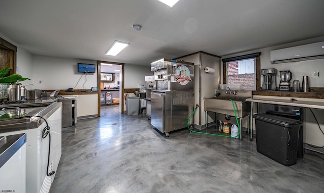 kitchen featuring stainless steel refrigerator, a wall mounted air conditioner, concrete floors, and white cabinets