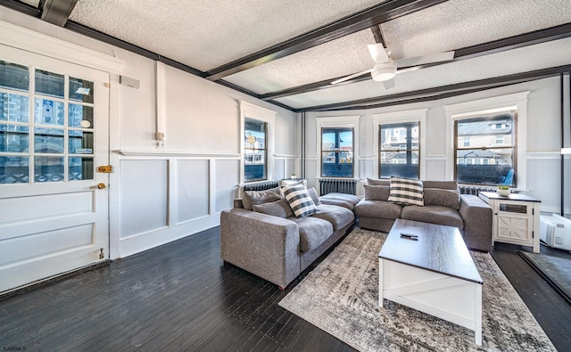 living room with dark hardwood / wood-style flooring, beam ceiling, and a textured ceiling