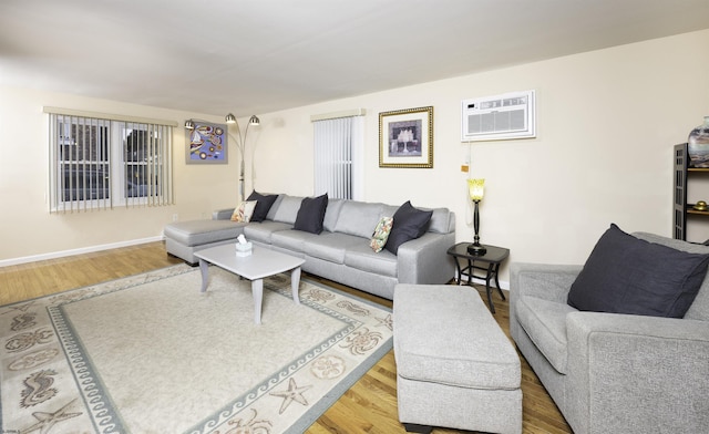 living room featuring hardwood / wood-style flooring and an AC wall unit