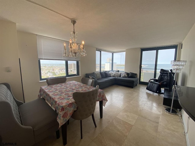 dining area featuring a water view and a chandelier