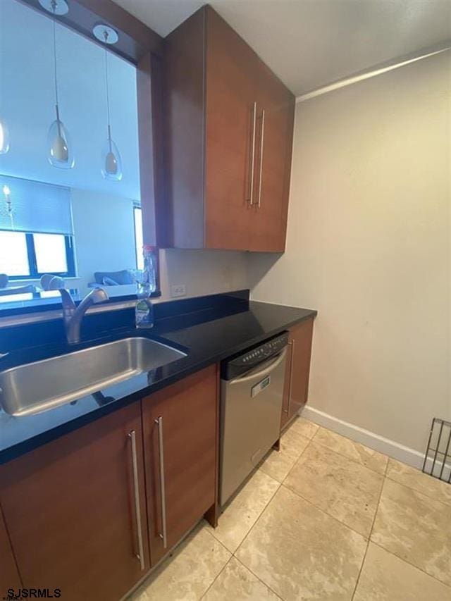 kitchen with light tile patterned floors, stainless steel dishwasher, and sink