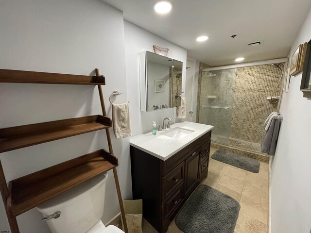 bathroom with tile patterned floors, toilet, vanity, and walk in shower