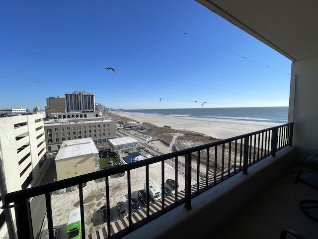 balcony with a water view and a view of the beach