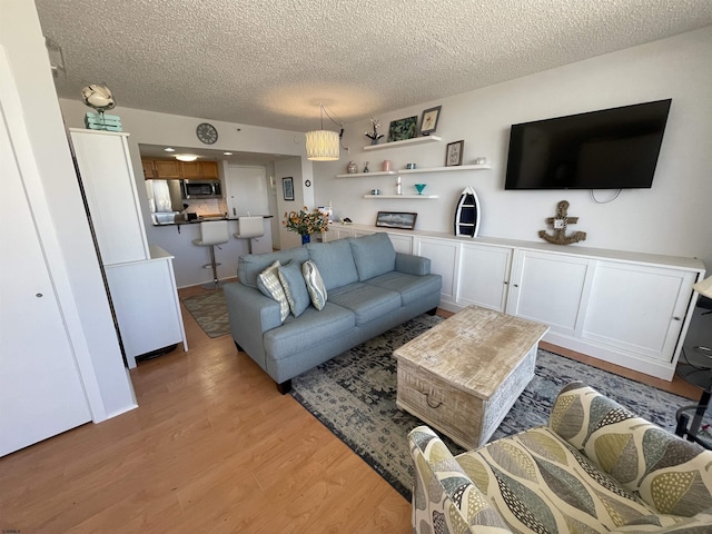 living room featuring light hardwood / wood-style flooring and a textured ceiling