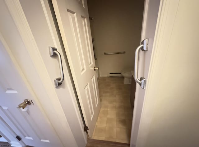 bathroom with toilet and a baseboard heating unit