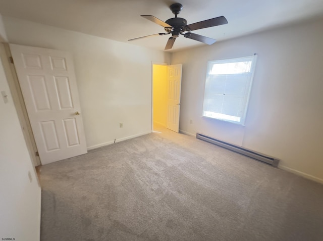 carpeted spare room featuring ceiling fan and a baseboard heating unit