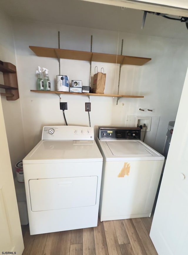 laundry area with light hardwood / wood-style floors and washing machine and dryer