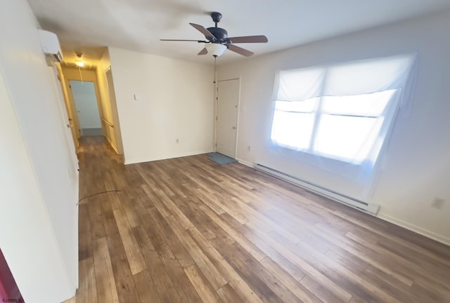 empty room with hardwood / wood-style floors, a baseboard heating unit, and ceiling fan