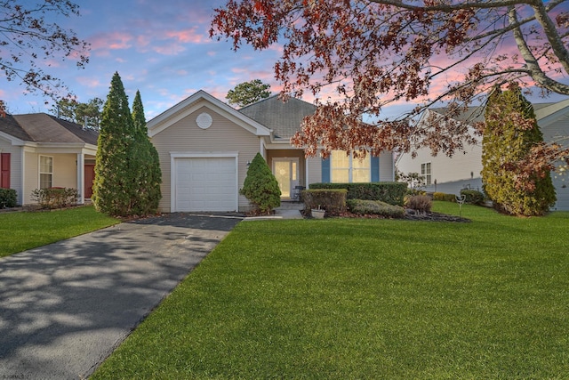 view of front of property with a garage and a lawn