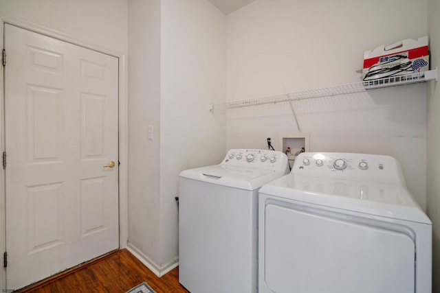 clothes washing area featuring washing machine and dryer and dark hardwood / wood-style flooring