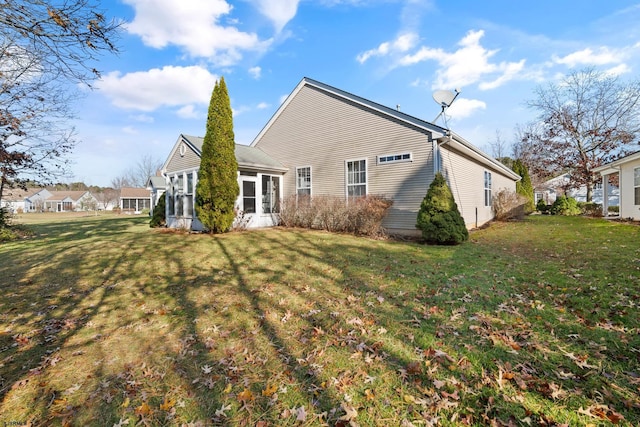 back of house with a sunroom and a yard