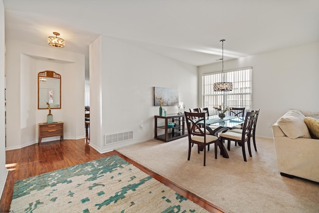 dining area featuring wood-type flooring and an inviting chandelier