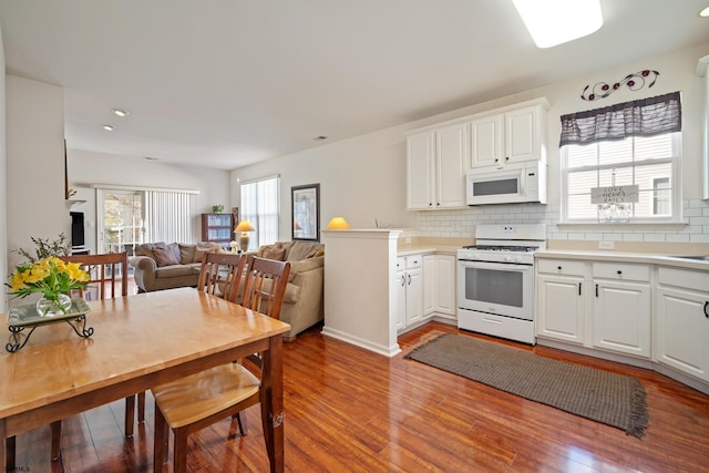 kitchen featuring white cabinets, decorative backsplash, white appliances, and light hardwood / wood-style flooring