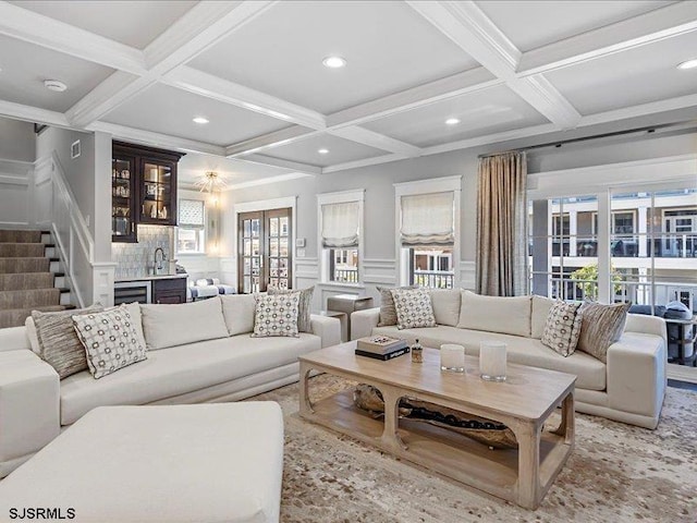 living room with beam ceiling, a healthy amount of sunlight, indoor bar, and coffered ceiling