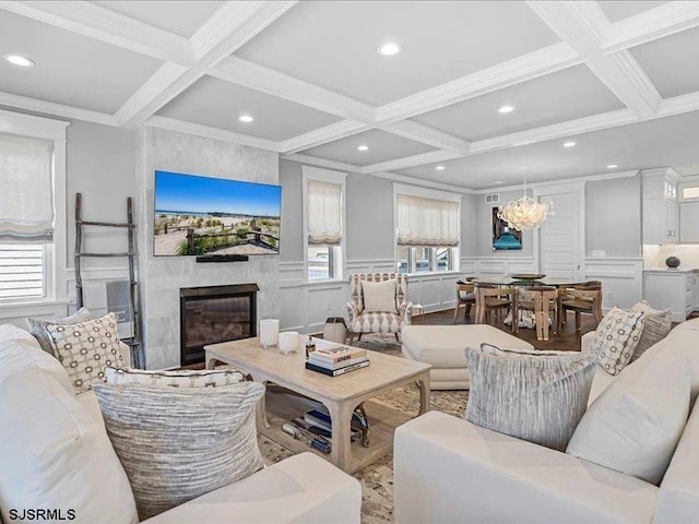 living room with beam ceiling, a large fireplace, and coffered ceiling