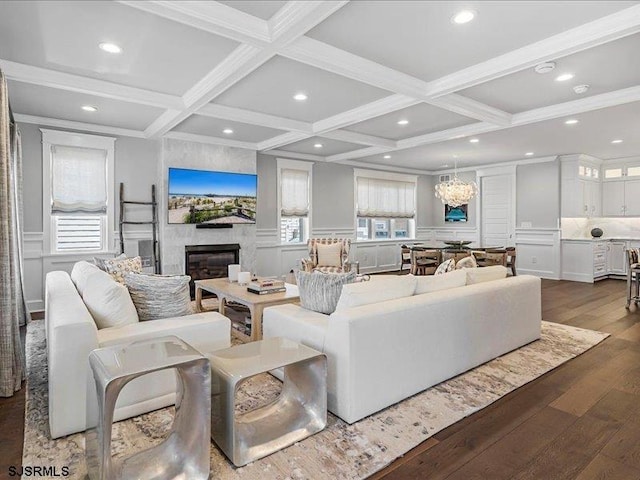 living room with beamed ceiling, dark hardwood / wood-style flooring, a chandelier, and coffered ceiling