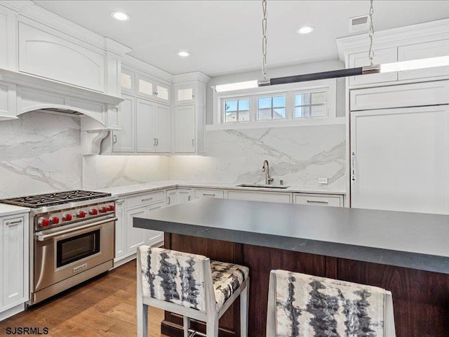 kitchen featuring white cabinets, decorative light fixtures, and premium range