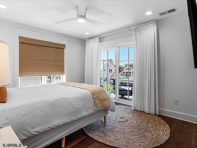 bedroom featuring multiple windows, access to outside, ceiling fan, and dark hardwood / wood-style floors