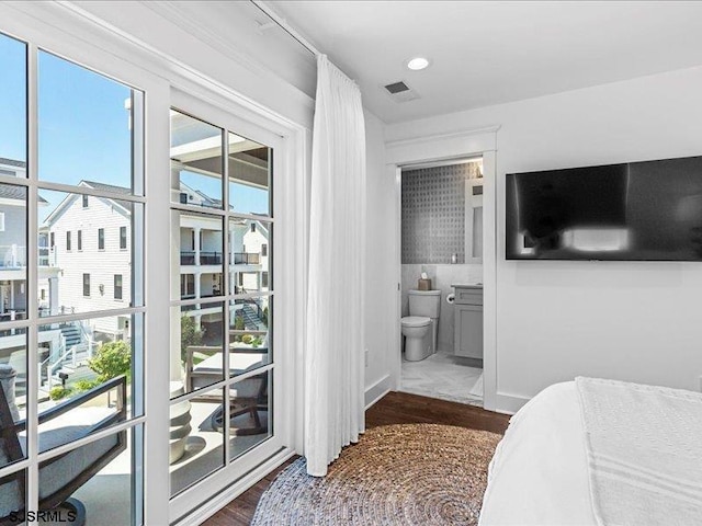 bedroom with dark hardwood / wood-style floors and multiple windows