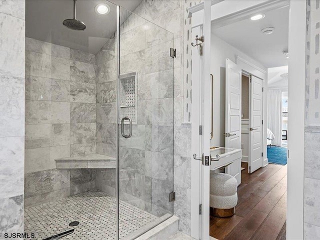 bathroom with wood-type flooring and a shower with door