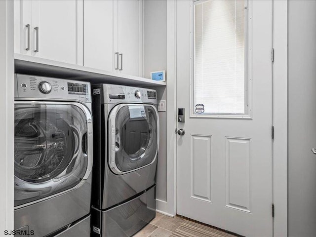 clothes washing area with light tile patterned floors, cabinets, and independent washer and dryer