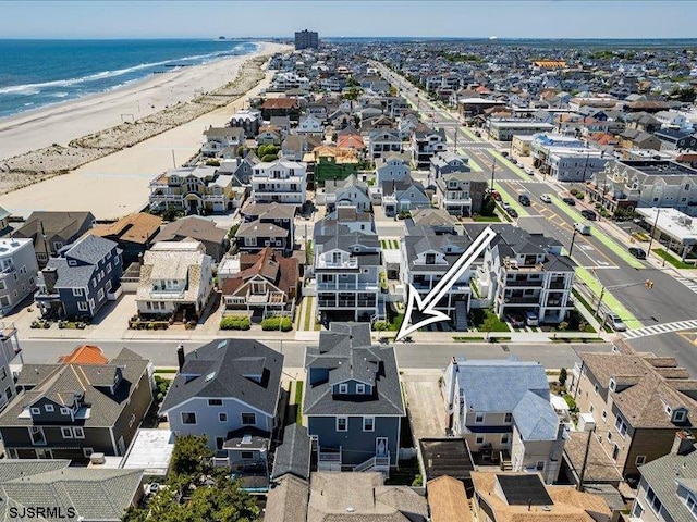 birds eye view of property featuring a water view and a beach view