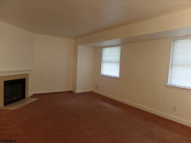 unfurnished living room with carpet and a tiled fireplace