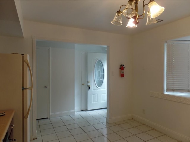 tiled entrance foyer with a notable chandelier