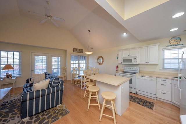 kitchen featuring white appliances, pendant lighting, a center island, white cabinetry, and a breakfast bar area