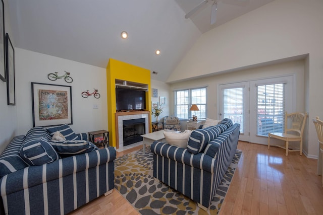 living room featuring ceiling fan, light hardwood / wood-style floors, and lofted ceiling