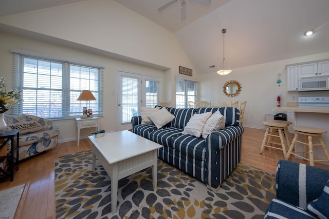 living room featuring ceiling fan, light hardwood / wood-style floors, and lofted ceiling