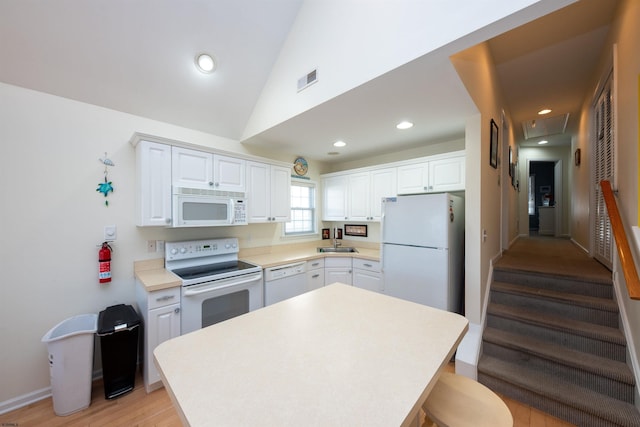 kitchen with white cabinetry, sink, vaulted ceiling, white appliances, and light wood-type flooring