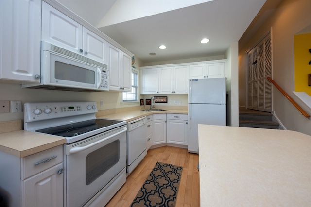 kitchen with white cabinetry, sink, lofted ceiling, white appliances, and light wood-type flooring