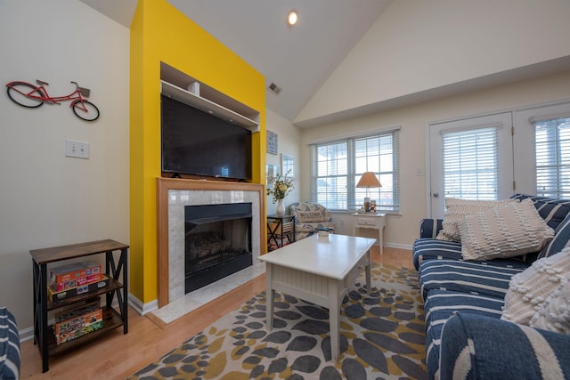 living room with light wood-type flooring and lofted ceiling