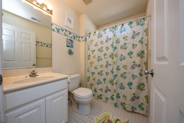 bathroom featuring tile patterned flooring, vanity, toilet, and walk in shower